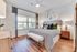 Bright and inviting bedroom with stylish decor, large windows, and exquisite wood flooring, perfect for relaxation.