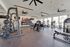 Modern gym with state-of-the-art equipment, expansive windows, and abundant natural light, creating an inviting workout space.
