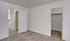 Bright and inviting bedroom with plush carpeting, featuring a spacious walk-in closet and elegant white doors.
