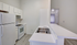 Modern kitchen with sleek white cabinetry, stainless steel sink, and spacious countertops, perfect for culinary enthusiasts.