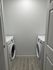 Modern laundry room featuring sleek white front-loading washer and dryer, optimized for space efficiency.