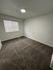 Bright and inviting room with soft carpeting, large window, and modern lighting; perfect canvas for personal styling.