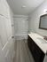 Bright and modern bathroom featuring a sleek bathtub, elegant vanity with ample storage, and contemporary fixtures.