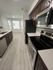Modern kitchen with sleek stainless steel appliances, elegant dark wood cabinetry, and bright natural light, creating a welcoming cooking space.