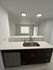 Contemporary kitchen with sleek design featuring quartz countertops, modern sink, and stainless steel appliances.