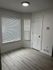 Bright modern corner with sleek blinds, fresh flooring, and elegant white trim, perfect for a cozy reading nook or home office.