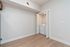 Contemporary apartment with in-unit laundry neatly tucked behind sleek folding doors, featuring stylish wood floors and modern finishes.