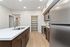 Modern kitchen with sleek stainless steel appliances, spacious pantry, and elegant wood cabinetry, perfect for culinary inspiration.