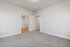 Modern bedroom with plush carpet and en-suite bathroom, offering a serene living space.