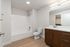 Modern bathroom featuring sleek wooden cabinetry, elegant white countertops, and chic lighting for a sophisticated ambiance.