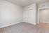 Bright and spacious room with plush carpet and ample natural light, featuring a sleek white closet and modern design.
