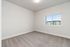 Bright and spacious bedroom with plush carpeting and a large window offering scenic views of modern architecture.