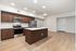 Modern apartment kitchen with sleek wooden cabinetry, stainless steel appliances, and a spacious island with pristine countertops.
