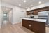 Modern kitchen with sleek appliances, elegant wooden cabinetry, and a bright, spacious hallway leading to a scenic view.