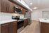 Modern kitchen with sleek wooden cabinetry, stainless steel appliances, and spacious countertops. Perfect blend of style and functionality.