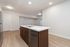 Modern kitchen with sleek island, stainless steel appliances, and elegant lighting, offering a spacious and inviting atmosphere.