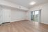 Modern apartment with sleek hardwood floors and bright natural light through sliding glass doors leading to a private balcony.