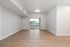 Bright, open-plan living area with elegant wooden flooring and sliding glass doors leading to a serene balcony view.