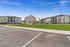 Contemporary apartment complex with charming gray exteriors, lush green lawns, and adjacent playground, offering inviting community living.
