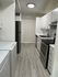 Contemporary kitchen with sleek stainless-steel appliances, modern cabinetry, and elegant wood flooring, perfect for culinary enthusiasts.