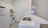 Modern kitchen with sleek white cabinetry, spacious countertops, and stainless steel appliances for a contemporary living experience.
