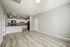 Modern open-plan kitchen and living area with sleek cabinetry, elegant lighting, and wood flooring.