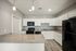 Modern kitchen with granite countertops, white cabinets, and stainless steel appliances.