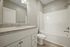 Bright and spacious bathroom featuring sleek granite countertops, a modern vanity, and a pristine white tile shower.