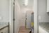 Modern laundry room with stacked washer-dryer and granite countertops.