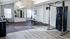 Modern home gym with sleek fitness equipment, bright windows, and polished wooden flooring, perfect for an energizing workout.