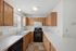 Bright and spacious kitchen with wooden cabinetry, sleek countertops, and modern appliances.