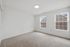 Bright and inviting bedroom with plush carpet and large windows, perfect for comfortable living in a serene setting.
