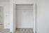 Bright empty closet space with double white doors and plush carpeting, perfect for organized storage.