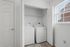 Bright laundry area featuring modern washer and dryer, complemented by a sleek shelf and natural light.