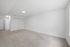 Spacious, well-lit room with plush carpet and elegant white walls, featuring double closet doors and modern lighting.