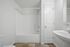 Modern bathroom with a sleek white bathtub, elegant sink, and contemporary finishes.