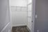 Spacious walk-in closet with sleek metal shelving and plush carpeting, ideal for organized storage.
