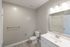 Modern bathroom featuring a sleek vanity with ample lighting, elegant fixtures, and a spacious layout.