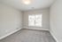 Bright and inviting bedroom featuring plush carpeting and a large window with ample natural light.