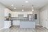 Modern kitchen with sleek white cabinetry, stainless steel appliances, and elegant pendant lighting on polished wooden floors.