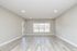 Bright and spacious living room with elegant wood flooring and large windows offering scenic outdoor views.