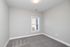 Bright and inviting bedroom with soft carpeting and a sunlit window, perfect for relaxation and comfort.