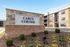 Inviting apartment complex of Carl's Corner with modern brick exterior and manicured landscaping under a clear blue sky.