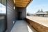 Charming outdoor patio with sleek dark siding and a modern covered seating area, perfect for relaxation and gatherings.