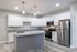 Modern kitchen with sleek stainless steel appliances, elegant granite countertops, and ample white cabinetry.