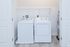 Modern laundry room with Whirlpool washer and dryer, featuring sleek shelving and elegant flooring.