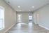 Bright and spacious living area with modern flooring and ample natural light, featuring access to a private patio and two additional rooms.