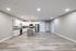 Modern open-plan apartment featuring a sleek kitchen with stainless steel appliances, elegant wood flooring, and ample natural lighting.
