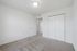 Bright, spacious room with plush carpet and ample closet space, perfect for relaxation.