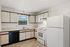 Bright and spacious kitchen with modern appliances, ample cabinet storage, and a charming window view.